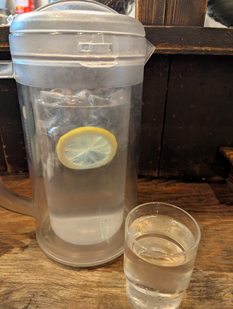 The cold water had slices of lemon in it
